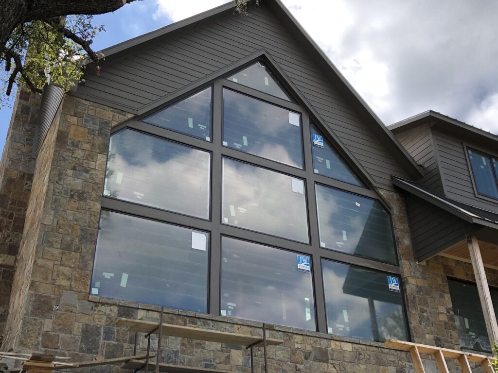 Exterior view of custom wall of windows in home under construction.
